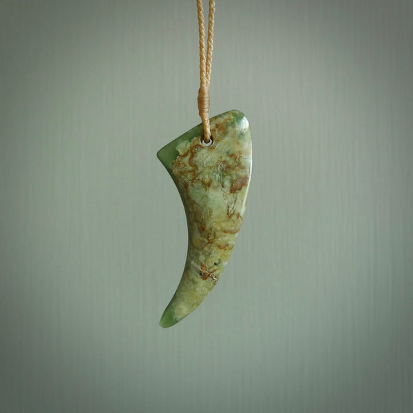 This is a lovely New Zealand Jade, pounamu drop pendant. Hand carved for us by Ric Moor. It is bound with an adjustable beige coloured cord which is length adjustable. Free worldwide shipping.