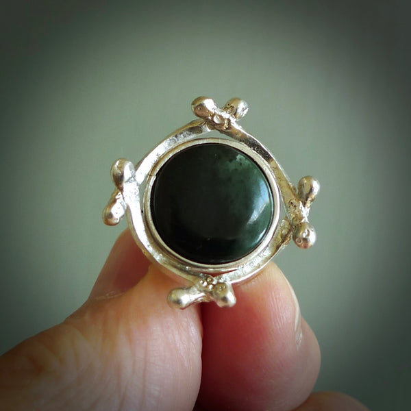 This is a handcrafted New Zealand Pounamu, Jade and sterling silver ring. This is a solid little work of art. We ship this worldwide for free and are happy to answer any questions that you may have about these or other products on our website. Delivered with Express courier and packaged in a woven kete pouch.
