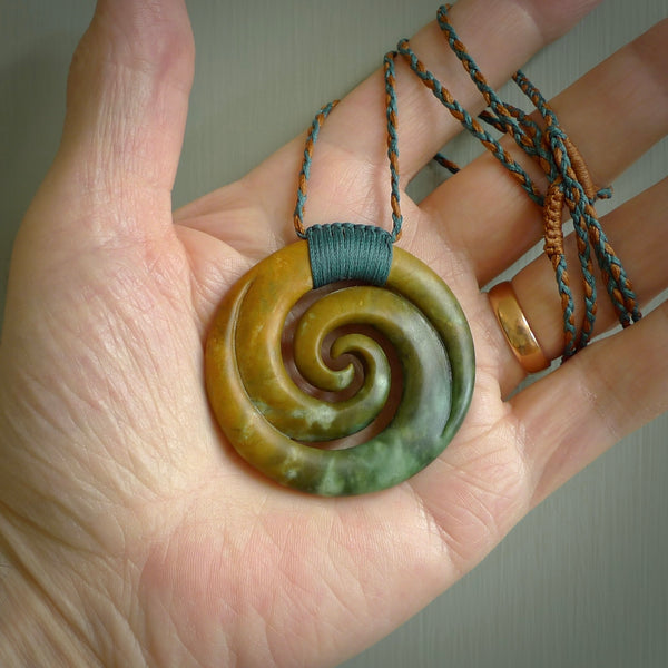 A hand carved koru pendant from New Zealand Jade. The cord is a Cobalt Blue and Chestnut colour and is length adjustable. A large hand made double Koru necklace by New Zealand artist Kerry Thompson.