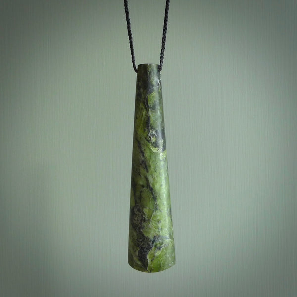 This photo shows a large jade drop shaped pendant. It a a lovely, colourful douglas creek jade. The cord is a four plait black and is adjustable in length. One only large, contemporary drop necklace from Jade, by Rueben Tipene.