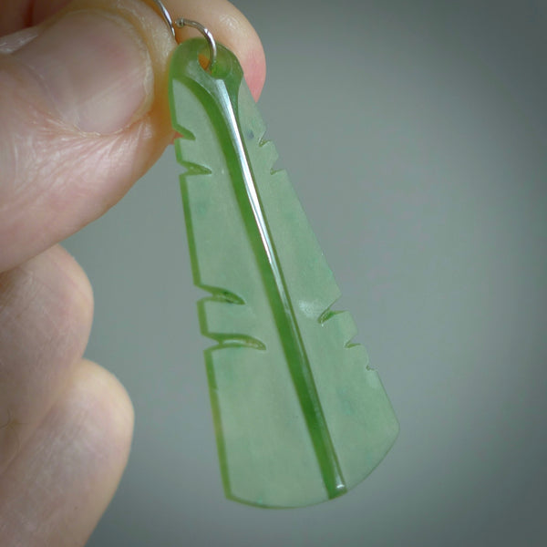 This picture shows New Zealand Pounamu, jade feather earrings with sterling silver hooks. Hand made unique and contemporary feather earrings by Kerry Thompson. Hand carved here in New Zealand from New Zealand Jade. One pair only.