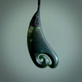 A hand carved large sized drop pendant with a koru carved into the front face. This is a piece of genuine jade jewellery, hand carved by Ric Moor. He has used New Zealand jade and has utilised his experience and carving skill to highlight the natural beauty of the stone. Delivered worldwide, postage is included in the price.