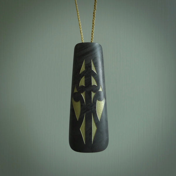 This photo shows a large Argillite, Pakohe Stone drop shaped pendant. It is a lovely, black stone. The cord is tan and a fixed length. One only large, contemporary drop necklace from Jade, by Rueben Tipene.