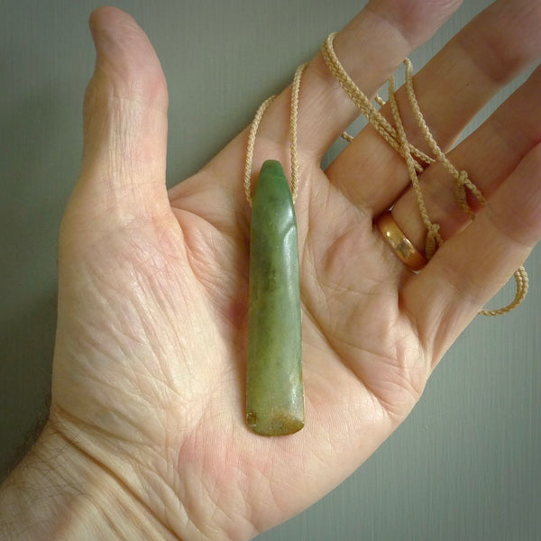 This is a lovely, large, New Zealand Flower Jade, pounamu drop pendant. Hand carved for us by Ric Moor. It is bound with an adjustable beige coloured cord which is length adjustable. Free worldwide shipping. The light reveals the internal structure and colour of the stone beautifully.