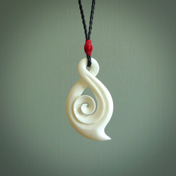 Hand carved twist with koru. Made from natural bone by NZ Pacific.