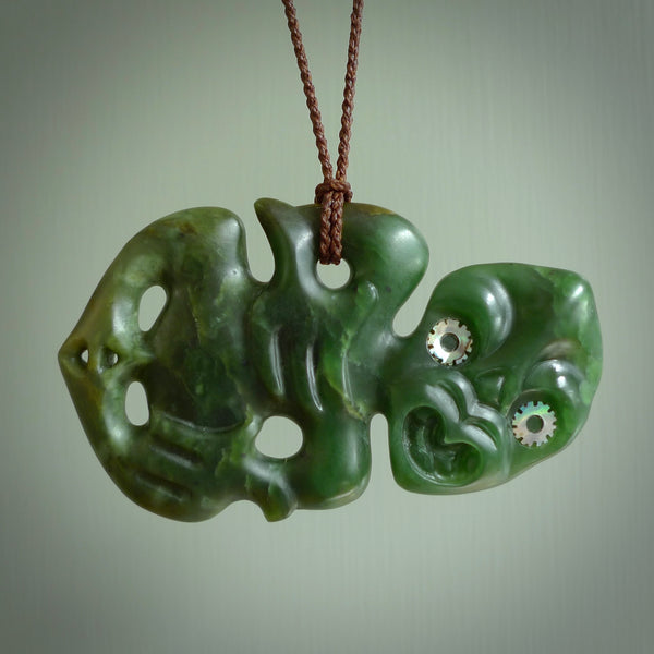 This is a large sized tiki - carved from gorgeous Marsden jade with Pāua Shell eyes. The craftsmanship is superb, this piece is as well carved as any we have seen. We have plaited an adjustable brown cord for this piece. 