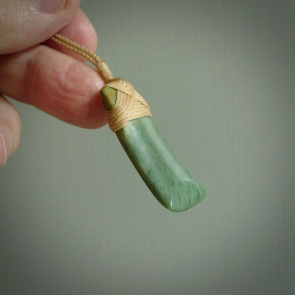 Hand carved from a lovely piece of local New Zealand Jade. The quality of the workmanship and design is outstanding - this is a piece you will want to wear all the time. We have suspended this from a 3-plait beige cord which can be adjusted with a couple of slip knots and beige binding.