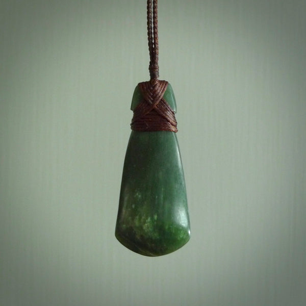Hand carved from a lovely piece of local New Zealand Jade. The quality of the workmanship and design is outstanding - this is a piece you will want to wear all the time. We have suspended this from a 3-plait brown cord which can be adjusted with a couple of slip knots and brown binding.