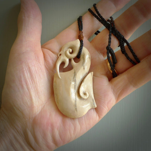 Hand made deer antler manaia pendant.  Hand carved by NZ Pacific. Manaia carved from deer antler pendant for sale online. Delivered to you on an adjustable cord.