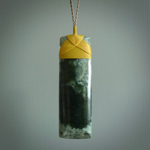 A large and beautiful hand carved toki pendant. This piece is carved from New Zealand flower jade by NZ Pacific. This is a wonderful large toki bound with a tan cord and a traditional lashing. A beautiful, traditional toki for sale online.