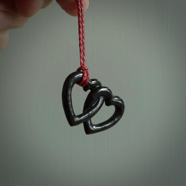 Hand carved double heart pendant made in black jade, green jade and jasper stone. Made by NZ Pacific. Carved from green jade, black jade and red jasper stone. Free delivery worldwide.