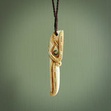 This picture shows a carved kāhu, hawk in bone. It is a drop shaped pendant. The artist has carved traditional decorative kowhaiwhai designs into the body and these run up the sides of the hawk. These have specific meanings. It is provided with a hand-plaited brown cord that is length adjustable. Shipping is included and we ship worldwide.
