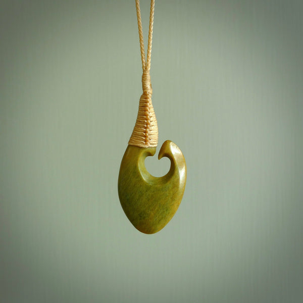 This matau, with koru, is carved from a very striking New Zealand jade. It is both intricate and simple in design - it has hidden folds and smooth curves. A piece to be worn or displayed - the carving and the jade are both magnificent. Hand made by Donna Summers.