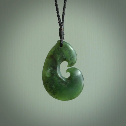 This photo shows a traditional hook pendant. It a a lovely deep green jade. The cord is a four plait black and is adjustable in length. One only, contemporary matau necklace from Jade, by Ric Moor.