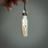 Hand carved engraved bone toki necklace hand made here in New Zealand. One only artistic toki pendant with hand plaited dark brown adjustable cord. Shipped to you with Express Courier. Stand out toki pendant for men and women. Bone Toki with engraved spiral on the back and paua shell insert on the front.