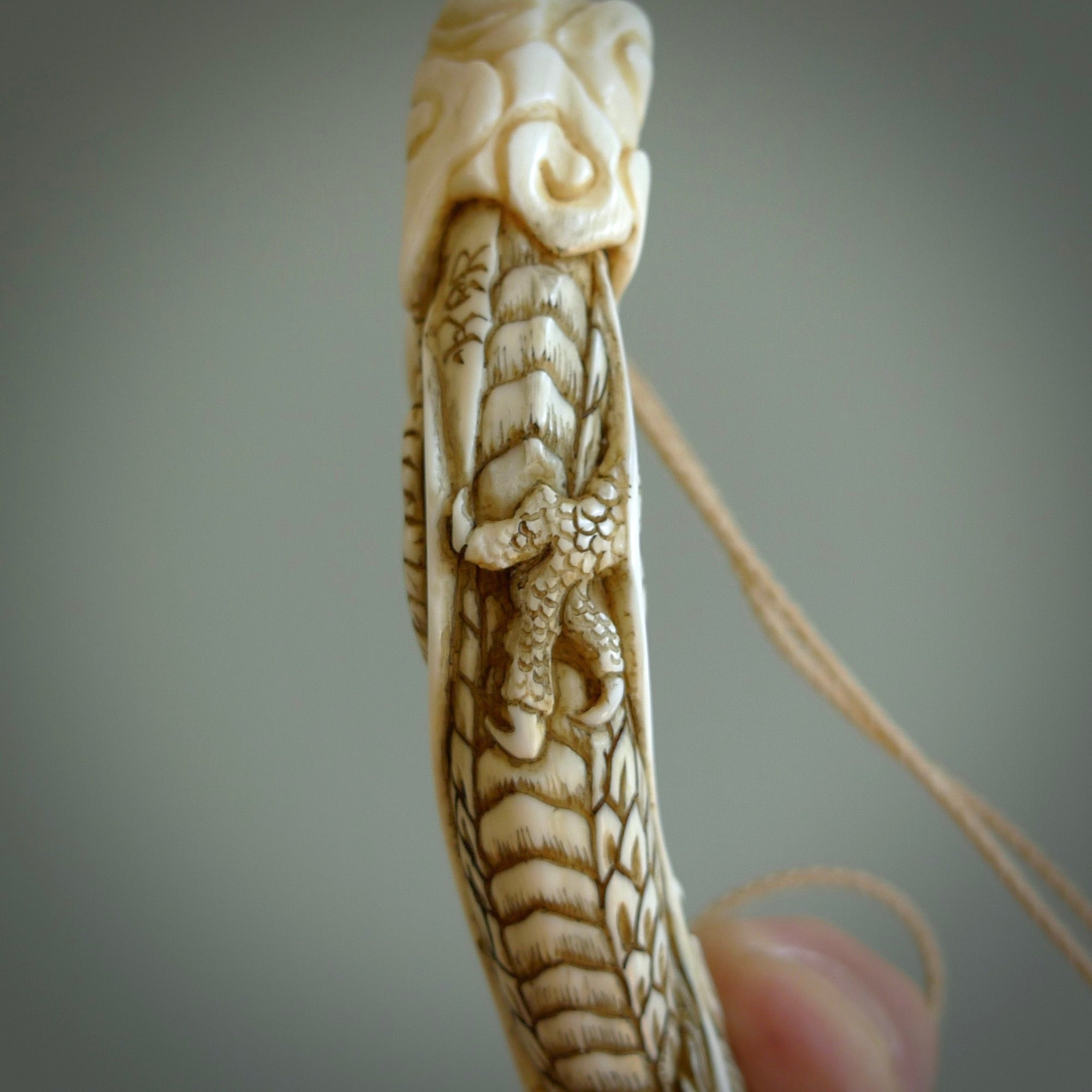 Hand carved dragon Pendant. Made from warthog tusk in New Zealand. Unique dragon necklace hand made from warthog tusk by master bone carver Fumio Noguchi. Spectacular collectable work of art, made to wear. One only pendant, delivered to you at no extra cost with express courier.