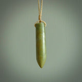 This picture shows a hand carved flower jade drop pendant by Ric Moor. The jade is a wonderful green with a shimmer of orange tones in the stone. It is suspended from a beige adjustable cord. Delivery is free worldwide.