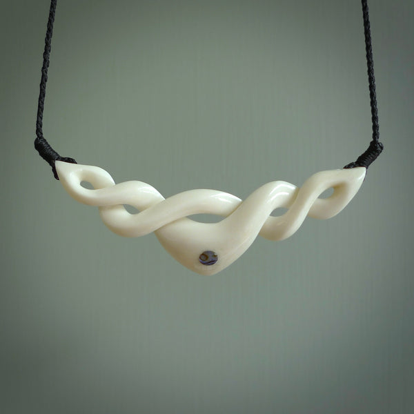 A hand carved twist pendant made from bone. This is a work of art carved by Fumio Noguchi who is renowned for his skill in bone carving. We deliver this pendant to you on a plaited black cord. Delivery with Express Courier is included in the price.