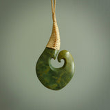 This matau, with koru, is carved from a very striking New Zealand jade. It is both intricate and simple in design - it has hidden folds and smooth curves. A piece to be worn or displayed - the carving and the jade are both magnificent. Hand made by Donna Summers.