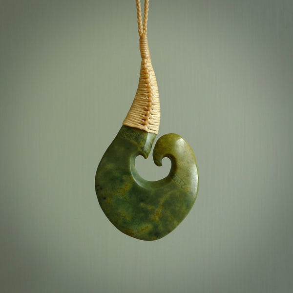This matau, with koru, is carved from a very striking New Zealand jade. It is both intricate and simple in design - it has hidden folds and smooth curves. A piece to be worn or displayed - the carving and the jade are both magnificent. Hand made by Donna Summers.