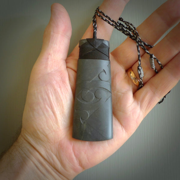 Hand carved New Zealand Argillite Toki by Rueben Tipene. We provide this large toki on an adjustable cord and ship to you in a kete pouch with Express Courier. This is a one off pendant that once sold will be removed from our site.