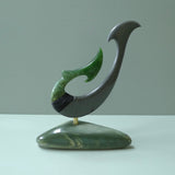 Hand carved large New Zealand Jade and Argillite Matau, hook carving displayed in a New Zealand Inanga Pounamu stand sculpture. Hand carved here in New Zealand by Kerry Thompson. This is a 'one only' sculpture, a beautiful display piece.