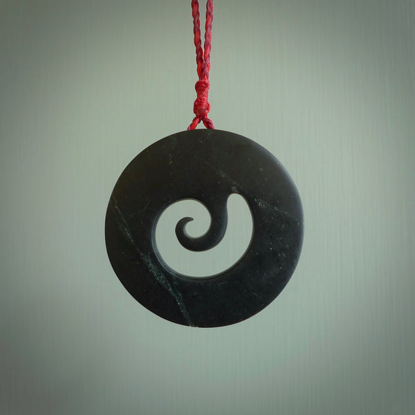 Hand made large New Zealand Pounamu, Jade Koru pendant. Hand carved in New Zealand by Rueben Tipene. Hand made jewellery. Unique large Greenstone Koru with adjustable juicy red/passion red cord. Free shipping worldwide.