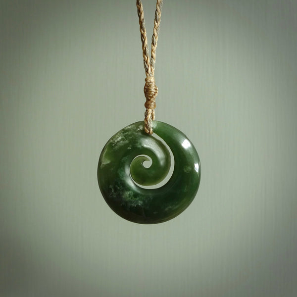 This pendant is a medium sized and gorgeous koru necklace carved from a deep green piece of New Zealand  Jade. Ross Crump carved this piece for us so the workmanship is outstanding. Handmade in New Zealand, a beautiful piece of jade jewellery.