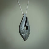 A hand carved large New Zealand Tangiwai Hook, Matau, necklace. The cord is a cosmos and blue moon grey colour and is length adjustable. A large sized hand made hook necklace by New Zealand artist Rueben Tipene. One off work of art to wear.