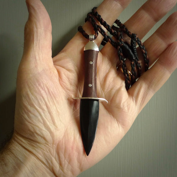 A striking hand carved knife pendant that we've called the blade. These are carved with a jade head and a hardwood handle. The cords are hand plaited in our waxed polyester which is robust, strong and durable. We ship these worldwide with express courier.