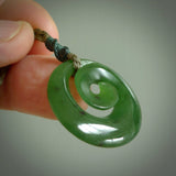 Hand carved New Zealand jade koru pendant. Delivered to you on a hand plaited manuka green cord which is adjustable. Free delivery worldwide.