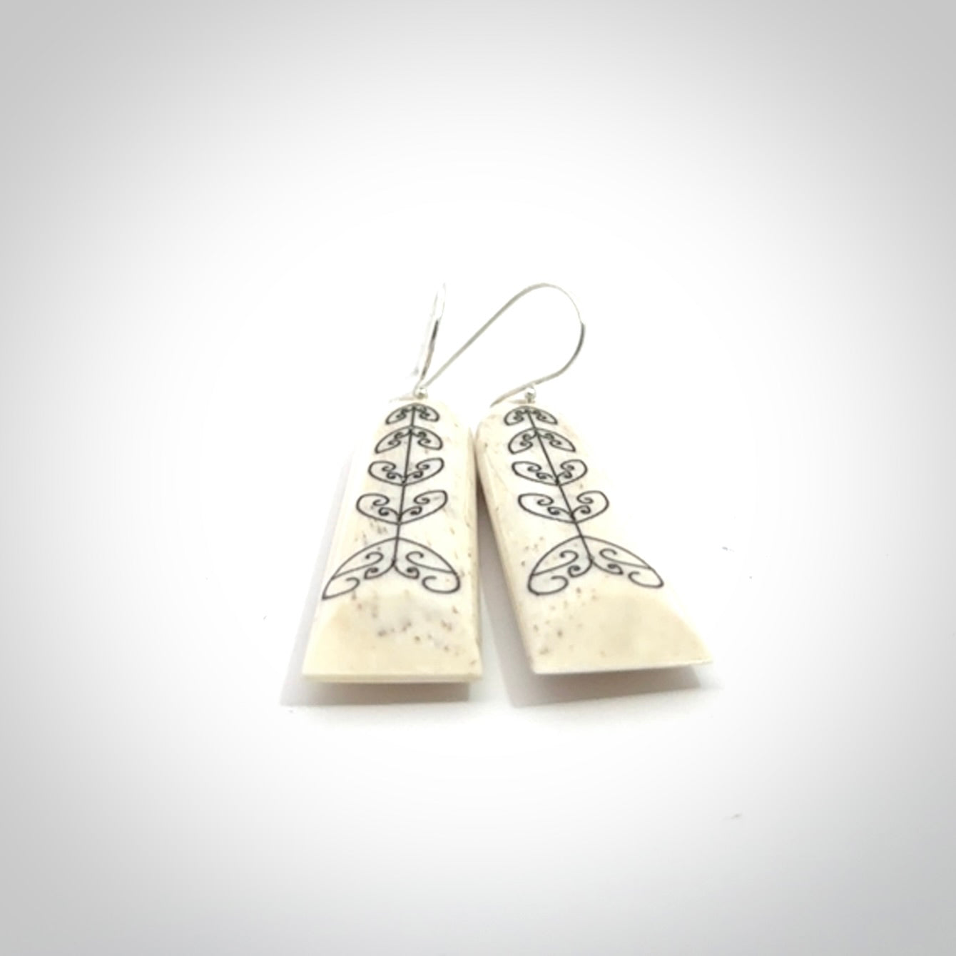 Hand carved bone koru earrings with double sided engraving.