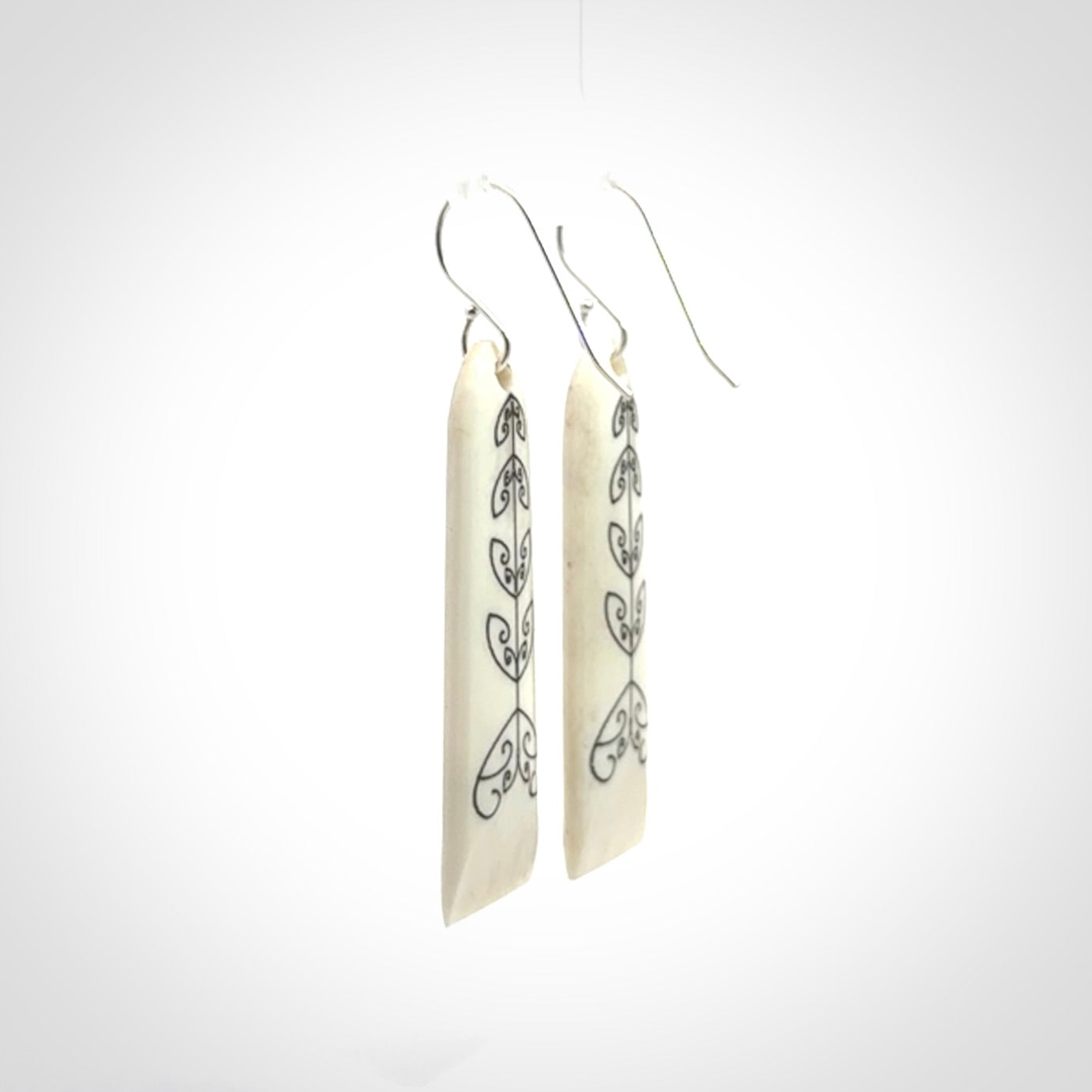 Hand carved bone koru earrings with double sided engraving.