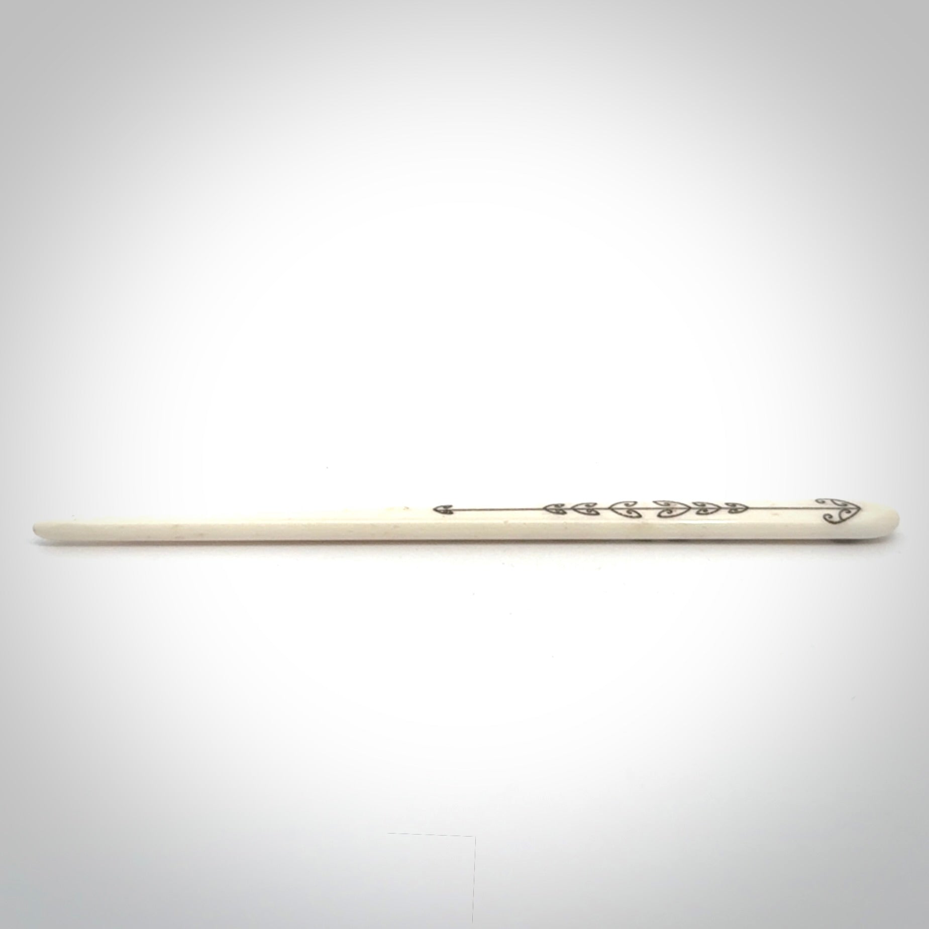Hand carved bone hair pin with double sided koru design.