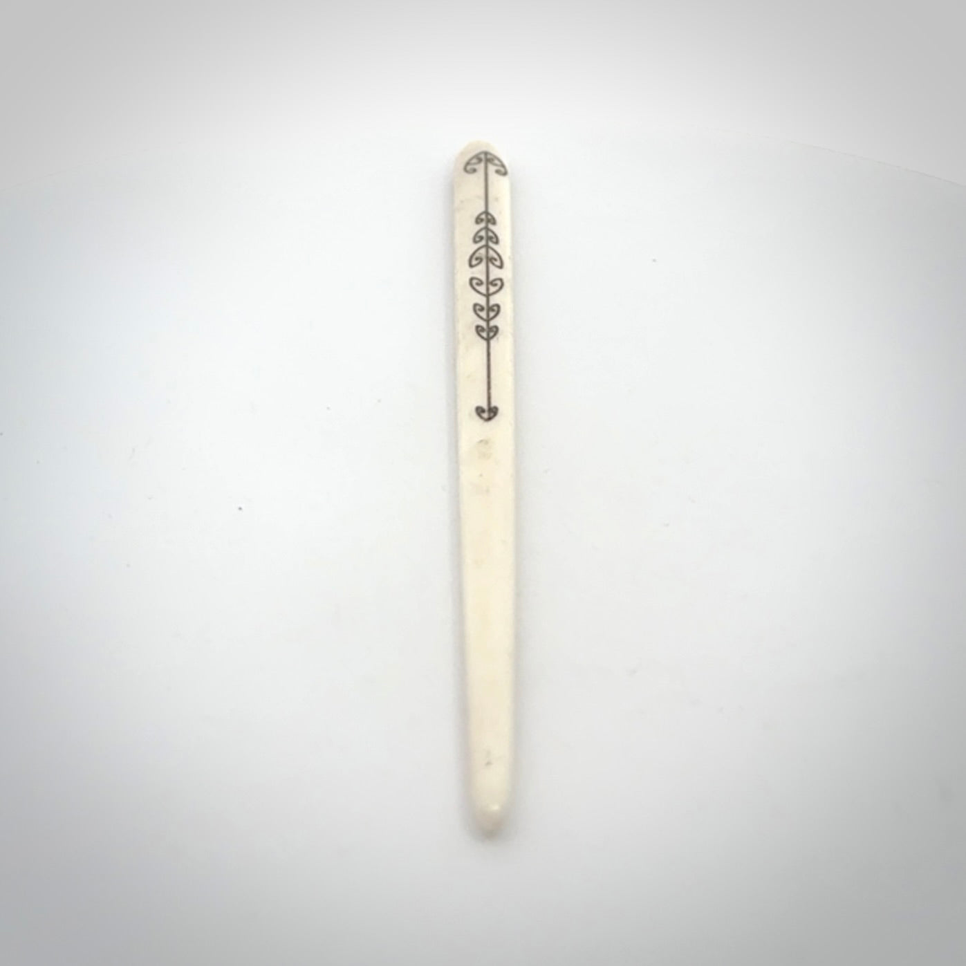 Hand carved bone hair pin with double sided koru design.