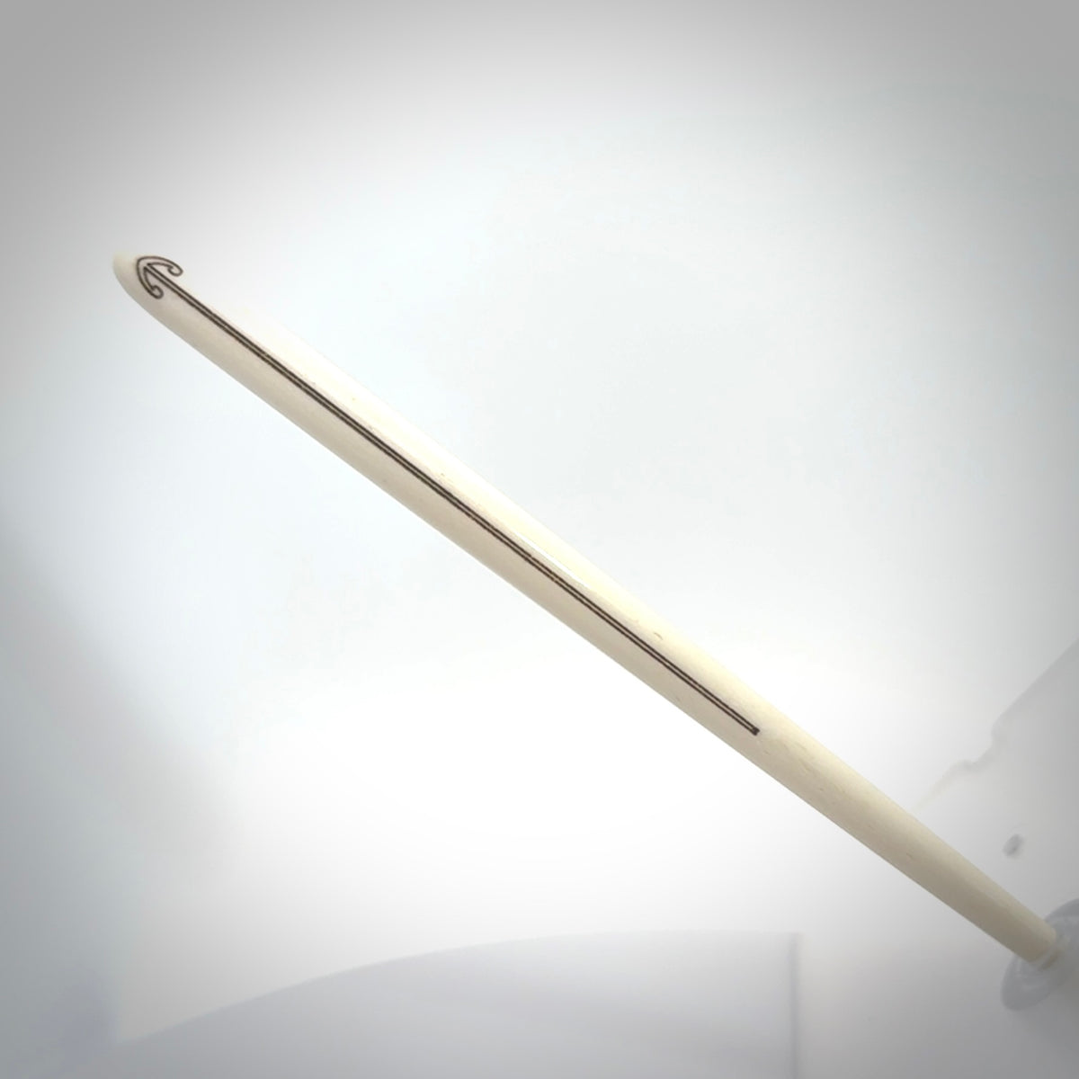 Hand carved bone hair pin with double sided koru design.