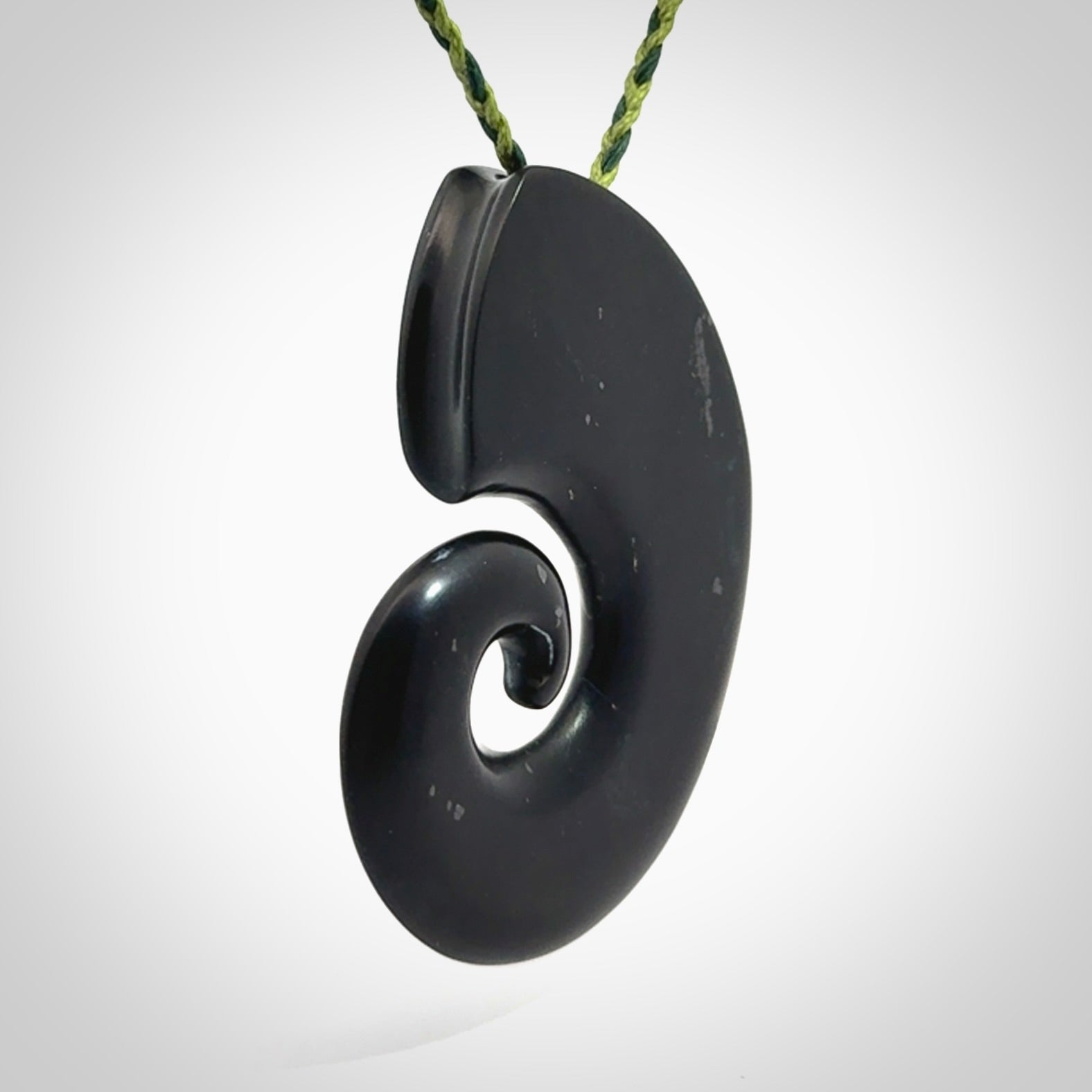 A hand carved koru pendant from New Zealand Tangiwai Pounamu. The cord is a Fern/Manuka Green colour and is an adjustable length. A large hand made Koru necklace by New Zealand artist Kerry Thompson.