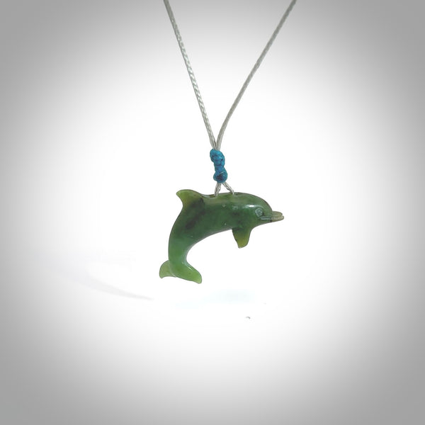 This is a gorgeous little dolphin pendant carved in green nephrite jade. The cord is fine, hand-plaited and length adjustable so you can position the little jade dolphin where it suits you best. Shipping is free worldwide.
