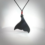 Hand carved New Zealand Argillite Stone whale tail pendant by Rueben Tipene. Hand made art to wear for lovers of the ocean. Delivered with express courier and delivered to you on an adjustable cord.