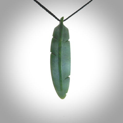 A hand carved large New Zealand Jade feather necklace. The cord is a black colour and is a fixed length. A large sized hand made Jade feather necklace by New Zealand artist Kerry Thompson. One off work of art to wear.