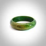New Zealand flower jade bangle. This is carved from a solid piece of jade and polished to a mirror finish on the outside. The inside is a satin finish. The jade is high grade New Zealand Marsden and is a beautiful coloured stone.