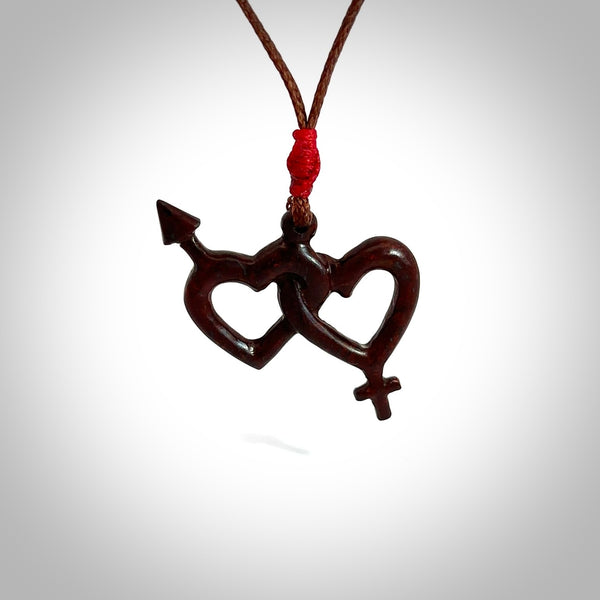 Hand carved double heart pendant made in your choice of black jade or jasper stone. Made by NZ Pacific. Carved from Red Jasper Stone and Black Jade. Black jade and red jasper stone heart with his and her symbols. Free delivery worldwide.