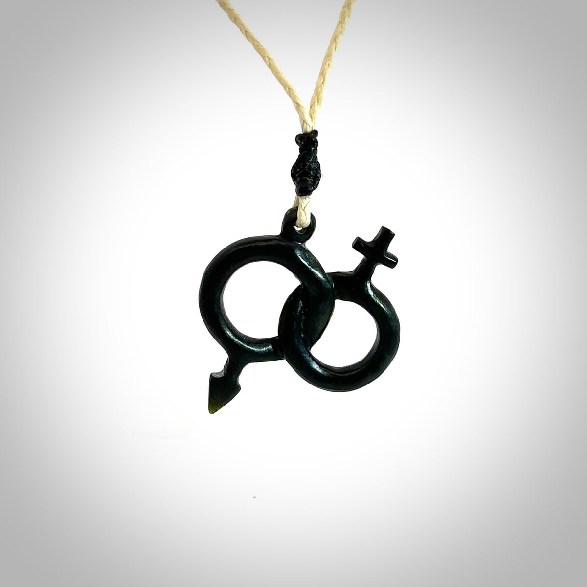 Hand carved double his and hers symbol pendant made in black jade and jasper stone. Made by NZ Pacific. Carved from black jade and red jasper stone. Free delivery worldwide.