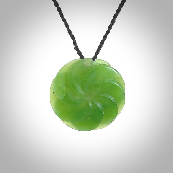 A large and beautiful hand carved 8 fold flower pendant. This piece is carved from New Zealand jade by Jeromy Van Riel. This is a wonderful large toki bound with a hand-plaited cord and a traditional lashing. A beautiful, traditional toki for sale online.