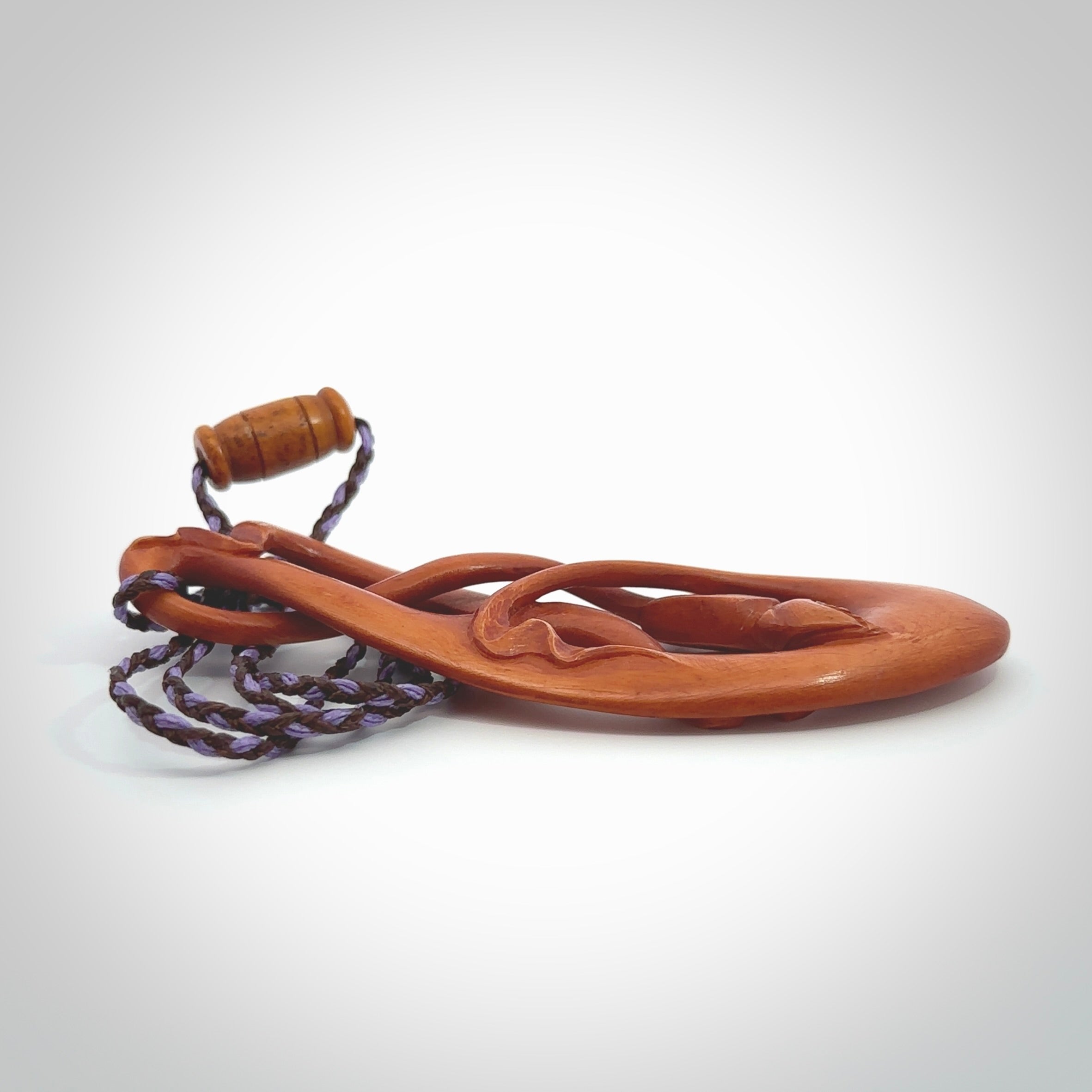 This necklace is carved from cow bone and stained with a homemade tea dye. It is a unique piece of wearable art that is sure to catch the eye. The shape is a complex twist form and has been beautifully hand carved by bone carver Yuri Terenyi.
