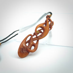 A one off beautiful piece of carved art. Hand carved for us by Yuri Terenyi and is a double manaia pendant. This is a wonderful ethnic bone pendant designed to be worn. It has been stained by a homemade tea dye in a bright gingery brown colour and we have hand plaited an adjustable cord in black with a burnt gold floret popper.