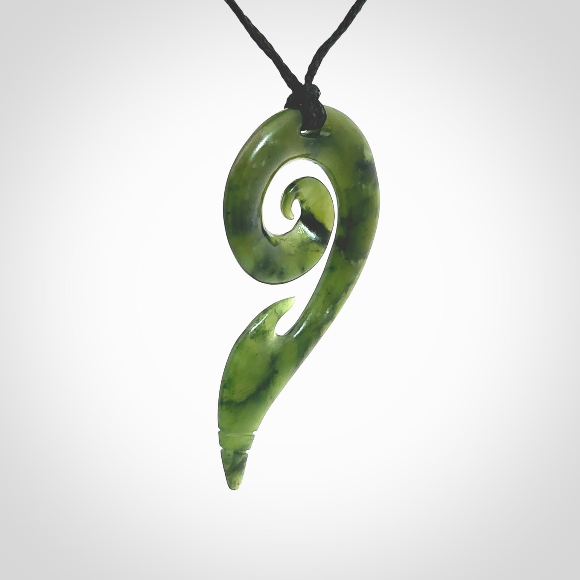 This photo shows a koru pendant carved from New Zealand Jade. The artist, Shaun Gardiner, has carved this beautifully. We provide this piece with an adjustable Black cord. This is a fantastic work of art, we have one only.