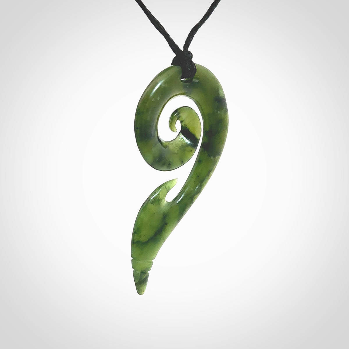 This photo shows a koru pendant carved from New Zealand Jade. The artist, Shaun Gardiner, has carved this beautifully. We provide this piece with an adjustable Black cord. This is a fantastic work of art, we have one only.