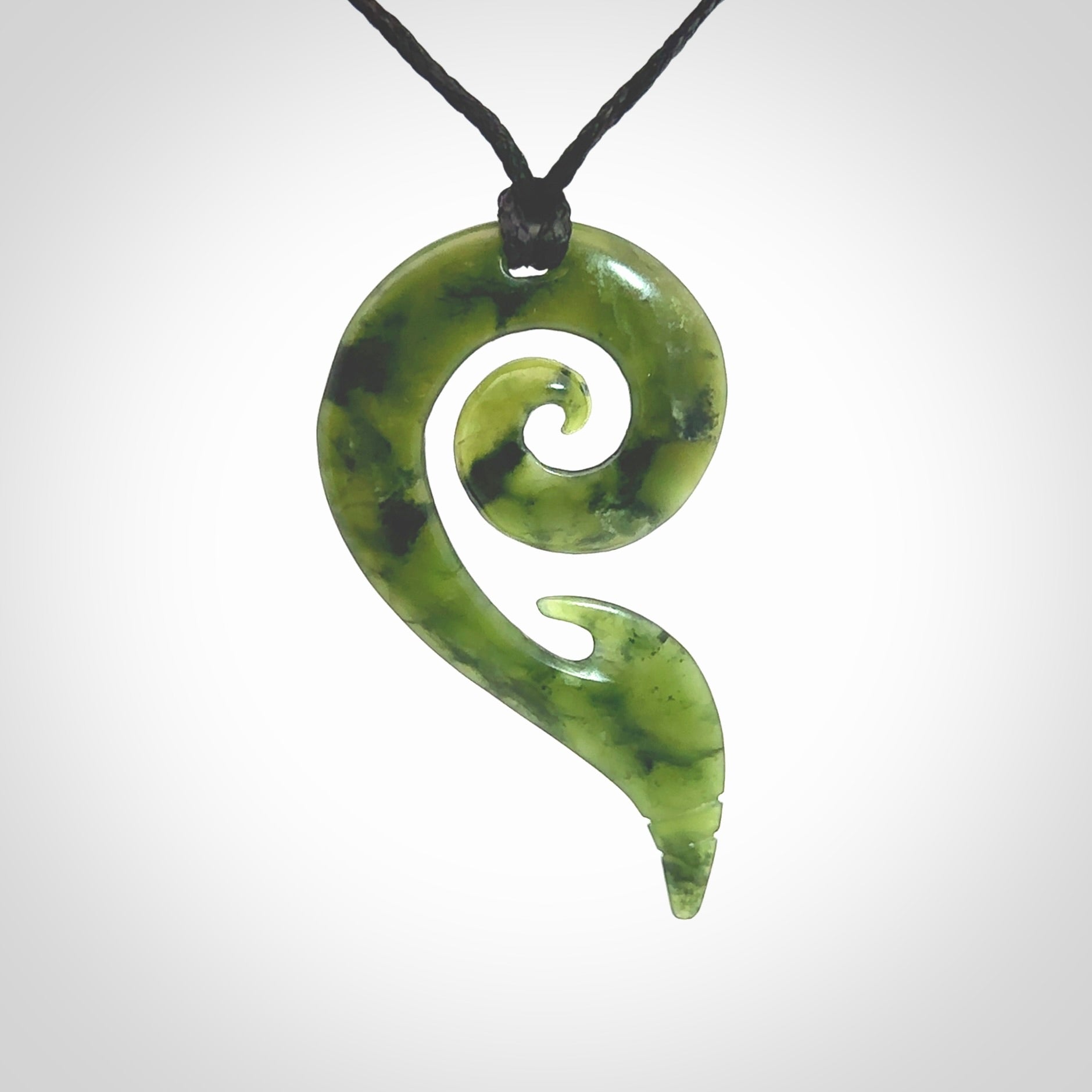 This photo shows a koru pendant carved from New Zealand Jade. The artist, Shaun Gardiner, has carved this beautifully. We provide this piece with an adjustable Black cord. This is a fantastic work of art, we have one only.