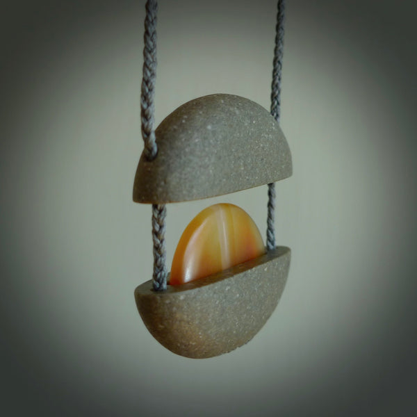 Greywacke stone pendant with Carnelian Stone insert. Hand carved by Rhys Hall for NZ Pacific. Handmade contemporary jewellery for sale online.